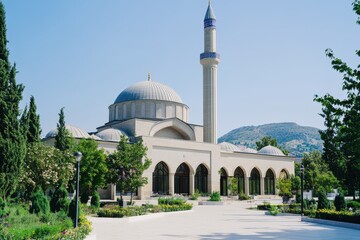 Sunny day at a mosque in a park, with mountains in background.  Possible use travel/tourism/culture