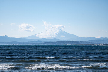 Mount Fuji, panoramic ocean view on the Japanese volcano Mt Fuji from Enoshima Island at daytime in Japan with blue sky and space for text.