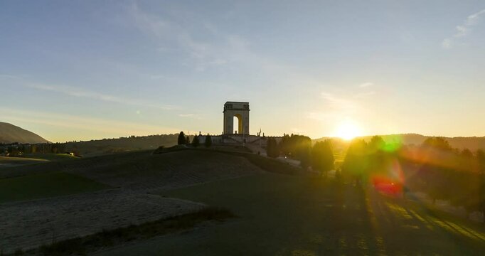 Sunrise aerial hyperlapse Asiago war memorial and Italian countryside with sun flare