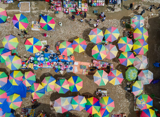 Aileu traditional market in Timor Leste seen from above, it can see the people, the traders' umbrellas and some of the products being sold by the traders.