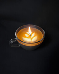 cappuccino coffee burning candle in the dark