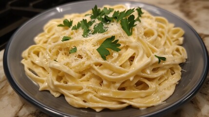 Plate of fettuccine Alfredo a creamy sauce garnished with fresh parsley and Parmesan