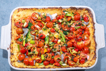 Stockholm, Sweden A mashed potato fish casserole with salmon, shrimp and fresh cut tomatoes before baking.