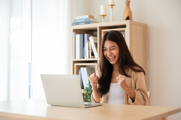 Happy euphoric young asian woman celebrating winning or getting ecommerce shopping offer on...