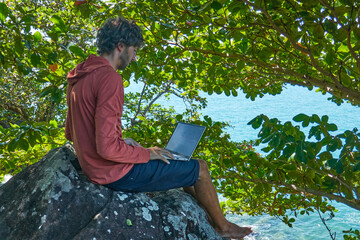 Workspace on a Cliff in the Shade of a Tropical Island &ndash; Working on a Laptop