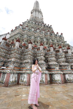 Young Asian woman in traditional Thai costumes at Wat Arun Ratchawararam.