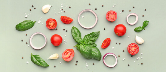 Fresh basil, cherry tomatoes and peppercorn on green background