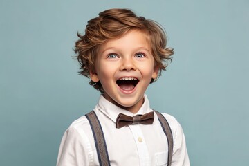 a delighted young boy with a bright expression and wearing a bow tie, looking upwards with an open mouth