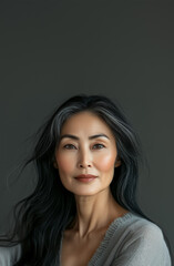 Fototapeta premium Elegant woman with long hair and natural beauty posing against a neutral background.