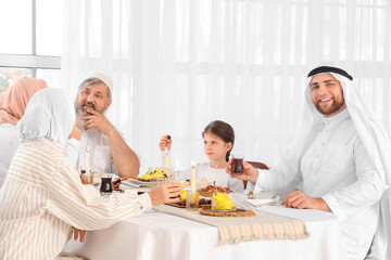 Happy Muslim family having dinner at home. Ramadan celebration