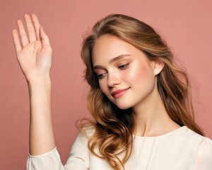 Fototapeta premium a woman with blonde hair holding her hand up, seemingly waving. Her expression is calm and her gaze is soft, against a backdrop