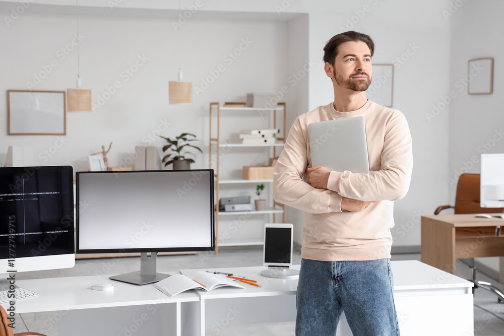 Wall mural Male programmer with laptop in  office