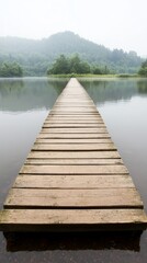 Fototapeta premium Serene wooden pier extending into a misty lake surrounded by lush greenery