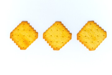 Three biscuit crackers in a square shape on a white background