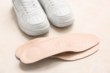 Shoes with orthopedic insoles on light background