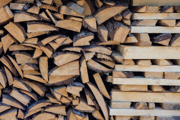 A stack of chopped firewood and logs arranged in neat rows for drying and storage.