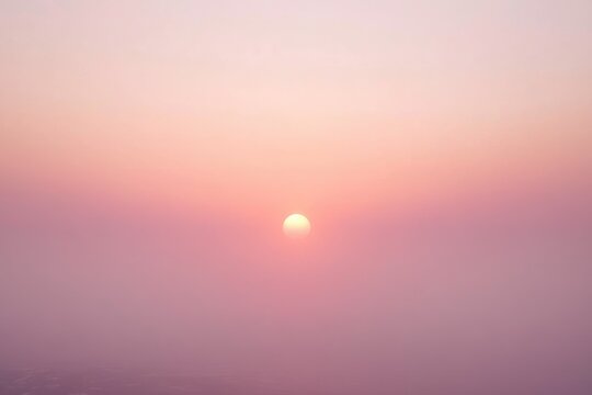 A hazy, pink sunset with a soft, muted sun centered in the frame. - Powered by Adobe