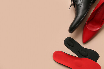 Different shoes with orthopedic insoles on beige background with space for text