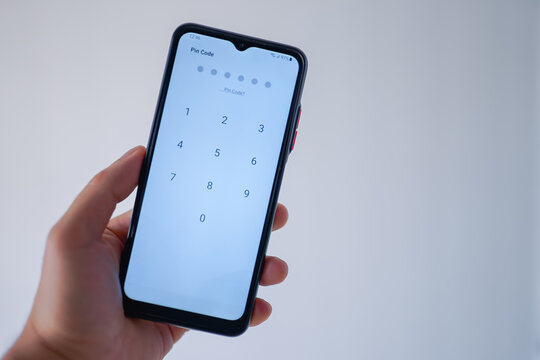 Person entering pin code to unlock the phone's screen 
