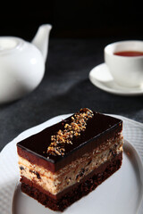 Piece of chocolate cake with tiramisu cream and sprinkle of nuts. Chocolate dessert.