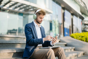 Modern businessman outdoors, using a tablet. Ideal for business, technology, and innovation themes.