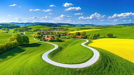 Serpentine road winding through green fields toward a small village