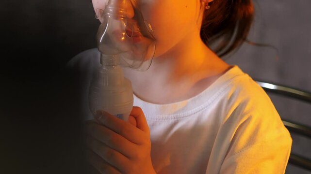 Little girl wearing a breathing medical mask. The girl does inhalation. Treatment of respiratory diseases. Little girl wearing a breathing medical mask. 