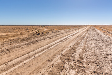 Travelling a remote country dirt road through the unfenced land of a large cattle station in the black soil country of western Queensland, Australia.