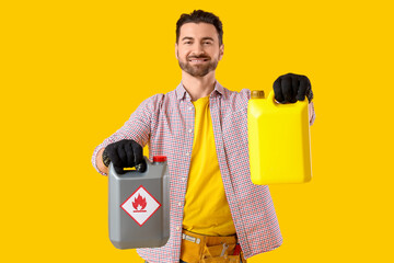 Young man with canisters on yellow background