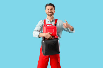 Male mechanic with canisters showing thumb-up on blue background