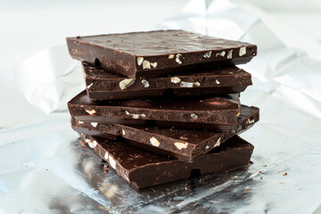 broken chocolate and hazelnuts on white table