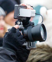 Fototapeta premium A person is holding a camera with a lens and a white object attached to it