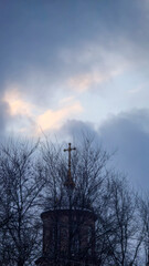 Blue sky with clouds, winter weather. Clouds on the background of trees.