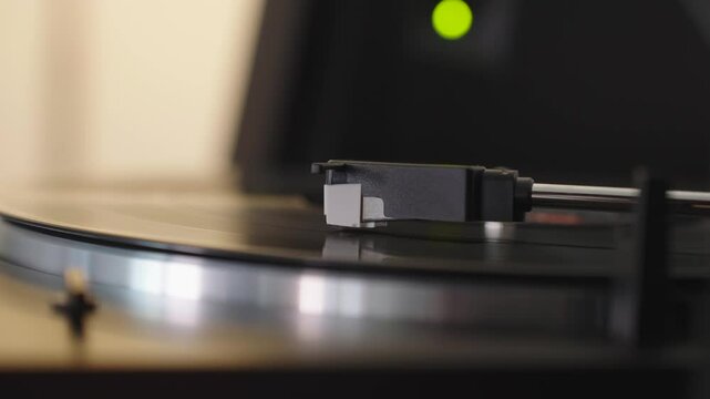 Vinyl record playing close-up, stylus of modern vinyl player. Turntable needle and phono cartridge, Hi-Fi audio equipment plays LP music collection at home. 