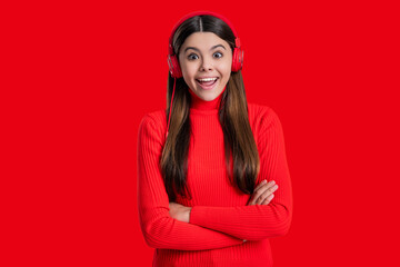 Amazed teen girl isolated on red. Student listen audio. Teen girl listen to music in headphones. Music concept. Generation z lifestyle. Millennial girl listening audio in music headphones