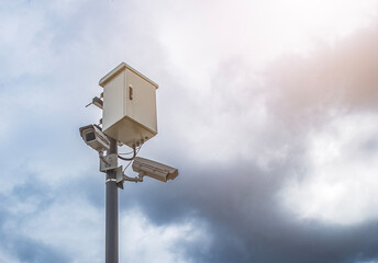 surveillance camera fining people and keeping control, against the background of severe thunderclouds with a thunderstorm. the problem of freedom and personal life in the 21st century