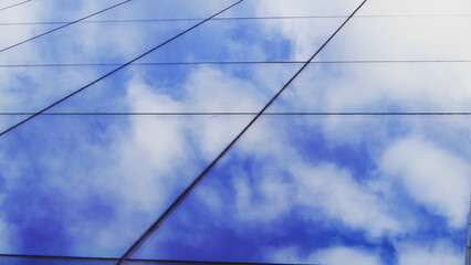 Fototapeta premium Blue Sky and Clouds Beautifully Reflected on the Surface of a Glass Building