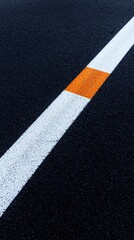 Asphalt road work planning concept. A close-up view of a road marking featuring a white line and a bold orange section on a dark asphalt surface.