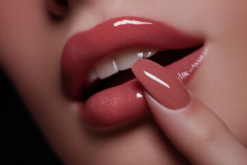 Red lips with glossy finish and manicure. Makeup advertisement