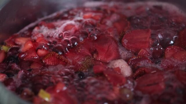 Various berries being boiled in a pot. Close-up