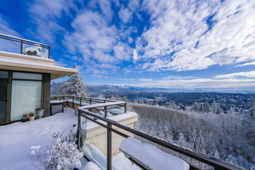 Snowed-in rooftop patio with panoramic winter view over valley below.