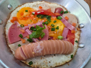 Close-Up of Thai Pan Eggs Breakfast with Sausage, Ham, and Fresh Vegetables