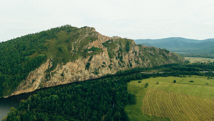 Obraz premium A tranquil river winding through rocky cliffs and dense forests, creating a breathtaking natural landscape captured in aerial drone footage
