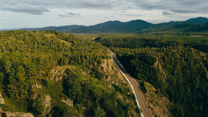 Fototapeta premium A river winding through mountains in Zakamensky District, Buryatia. Majestic peaks and serene natural beauty.