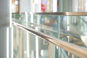 A metal railing with a glass top. stainless steel handrail.