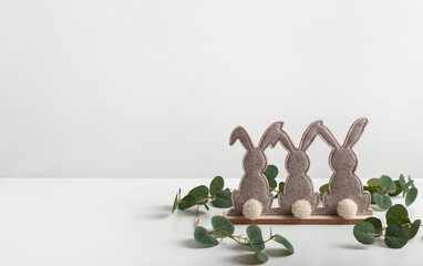 Decorative easter bunnies  with branch of eucalyptus. Easter background with copy space for your text.

