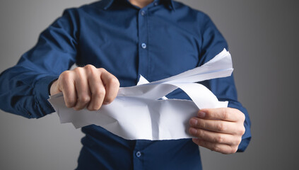 Business man tearing contract at office.