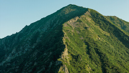 Breathtaking sunset over the Barguzin Mountains, casting golden hues across the rugged peaks and...