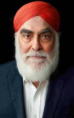 A man with a beard and a red scarf on his head. He is smiling. The man is wearing a blue suit and white shirt