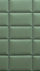 Fototapeta premium The surface texture of artificial leather in pistachio color, stitched in the form of rhombuses, squares, rectangles. 
